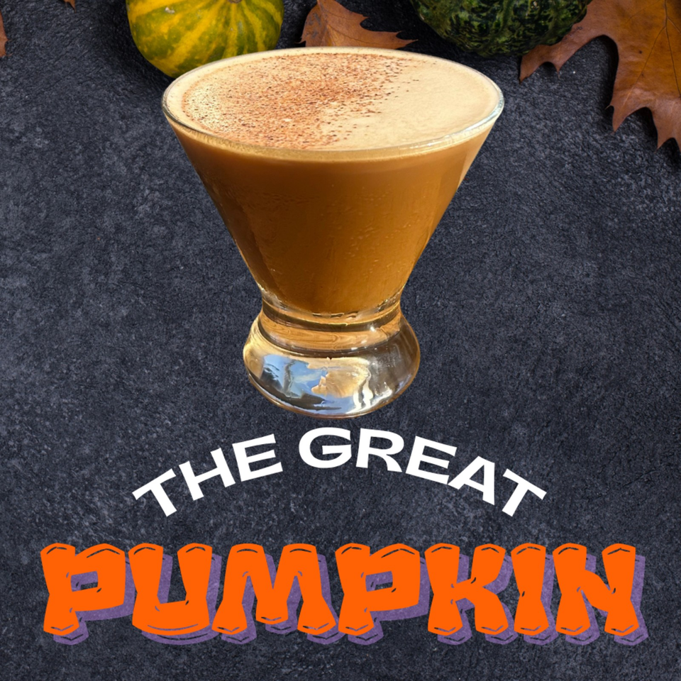 Golden pumpkin cocktail with frothy topping in a stemmed glass, surrounded by autumn leaves and labeled “The Great Pumpkin.”