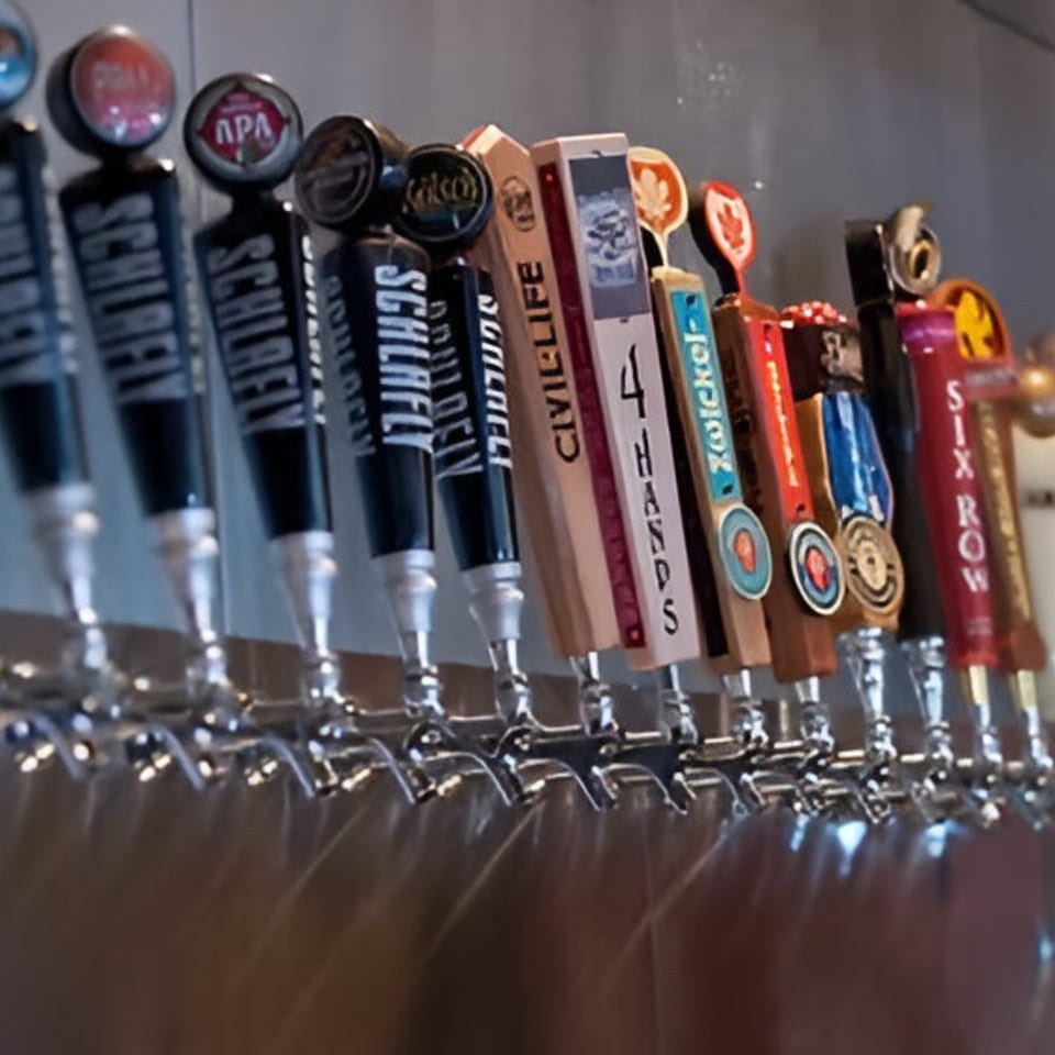 A row of various beer taps with different brand handles at Felix's Pizza Pub.